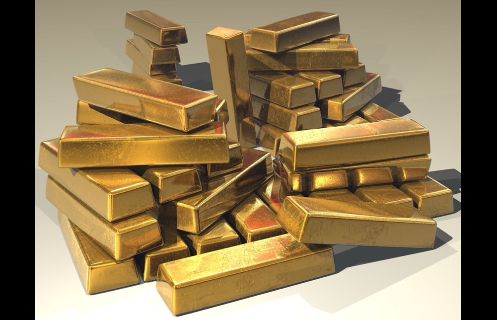 A large pile of gold bars messily stacked on a white background