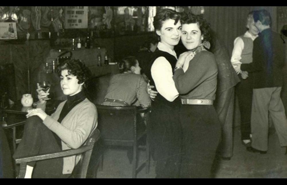 Black and white photograph of two women embracing at a club in the 1950s