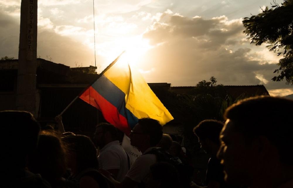 Colombian flag flying above the heads of people walking