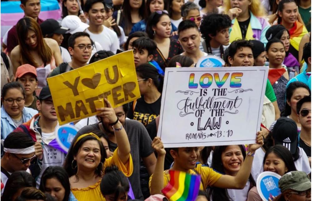 A sign at the annual Metro Manila LGBTQIA+ Pride Parade quotes scripture from Romans 13:10 – ‘Love is the fulfilment of the law’ 