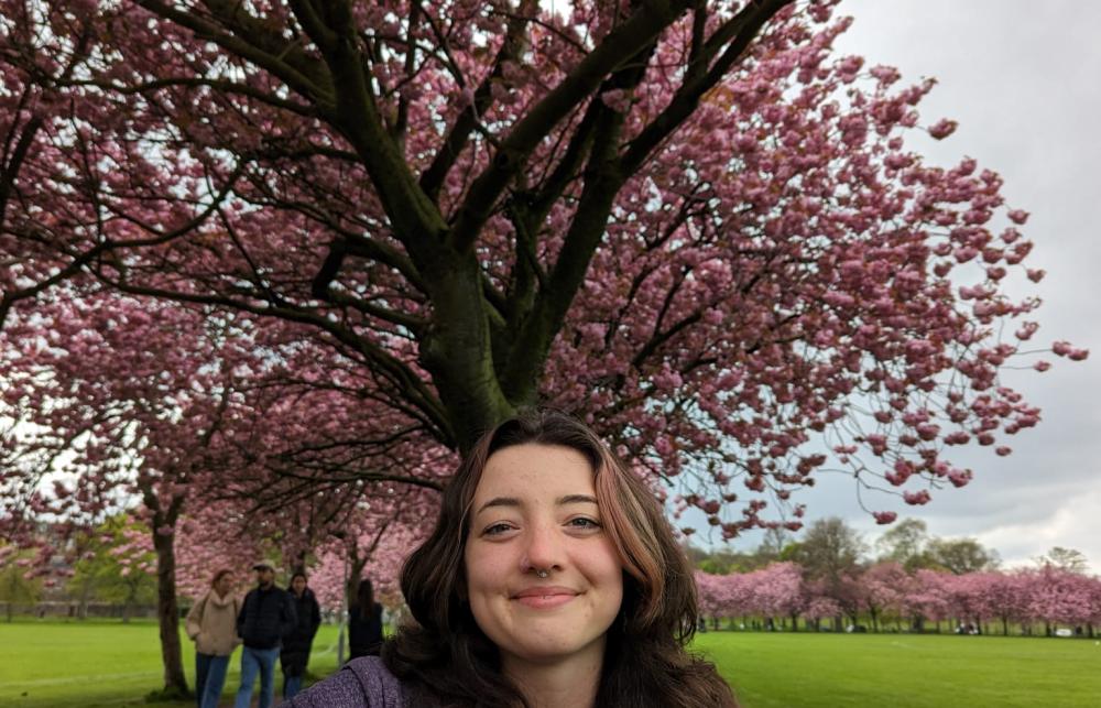 Photo of Elliana Effird in front of a cherry blossom tree.
