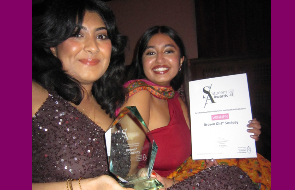 Photo of co-presidents Wardah and Kaashvi at the Student Awards. Wardah is holding an award made of glass and Kaashvi is holding a certificate that reads 'Student Awards: Winner: Brown Girl Society'. They are both smiling and wearing beautiful, ball-like dresses. 