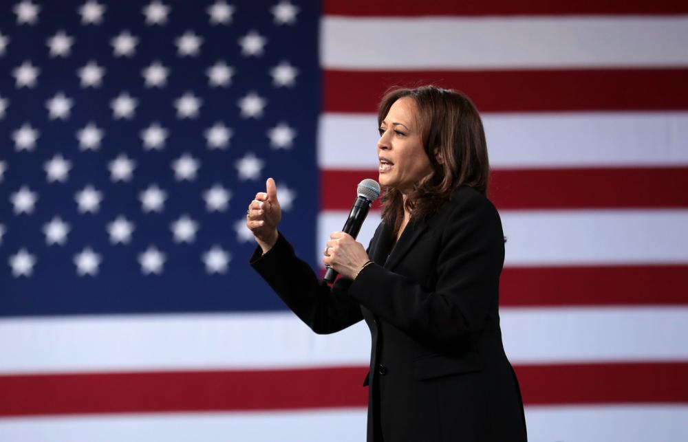 Image of Kamala Harris speaking, with an American flag background.