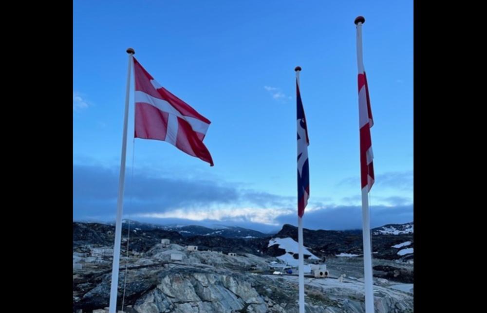 The Danish flag flying over a collection of sled dog kennels in Ilulissat, Kalaallit Nunaat